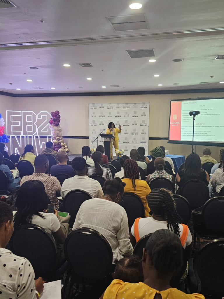 Audrey Morison speaking at a packed immigration seminar on the EB2 NIW visa process, addressing attendees about consular processing and interview preparation.